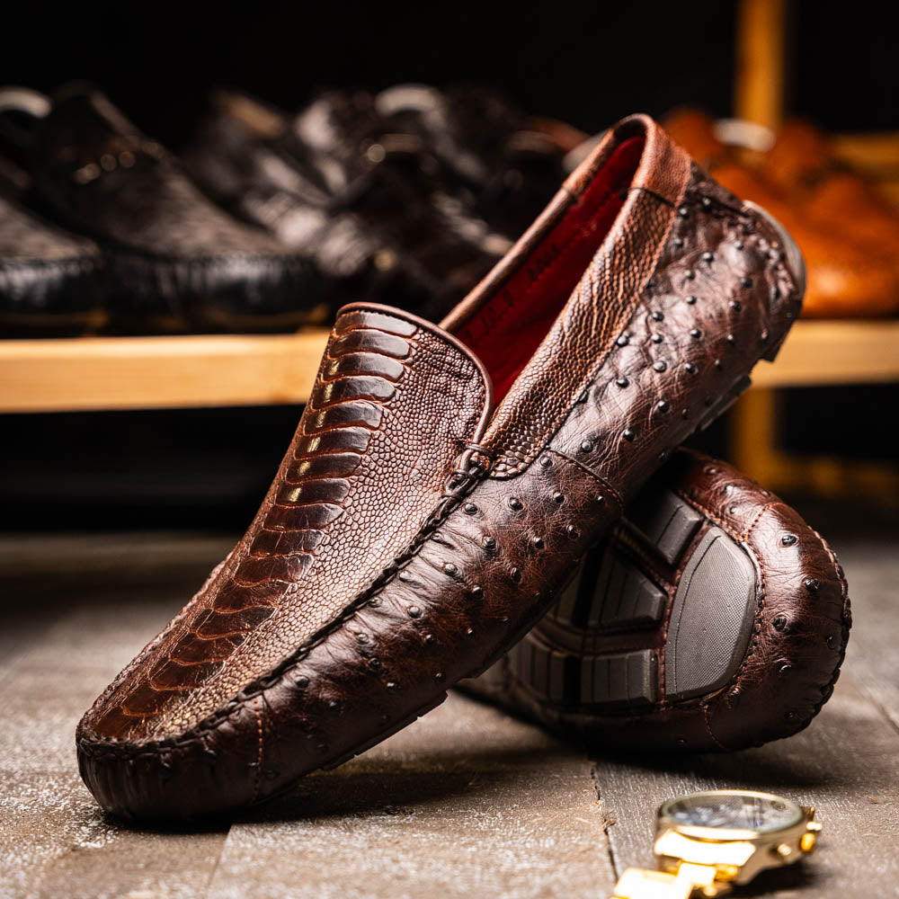 The Alba Kango Tabac by Marco Di Milano: brown textured leather loafers with visible stitching, one flat and one side-propped to reveal the sole—luxury footwear with artisanal hand-painted finishes.