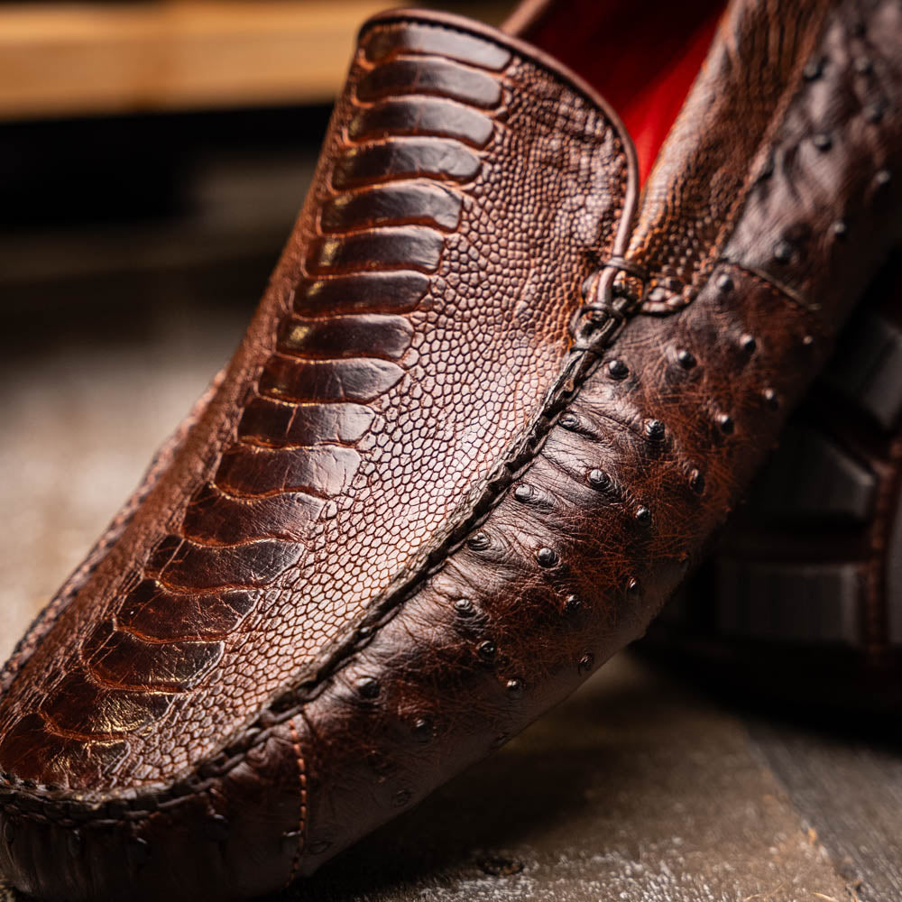 The Alba Kango Tabac by Marco Di Milano: brown textured leather loafers with visible stitching, one flat and one side-propped to reveal the sole—luxury footwear with artisanal hand-painted finishes.
