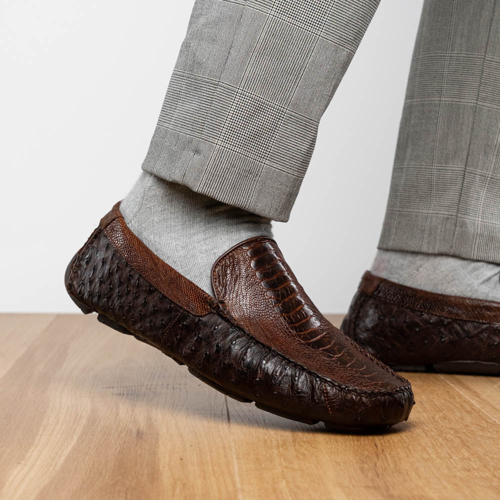 The Alba Kango Tabac by Marco Di Milano: brown textured leather loafers with visible stitching, one flat and one side-propped to reveal the sole—luxury footwear with artisanal hand-painted finishes.