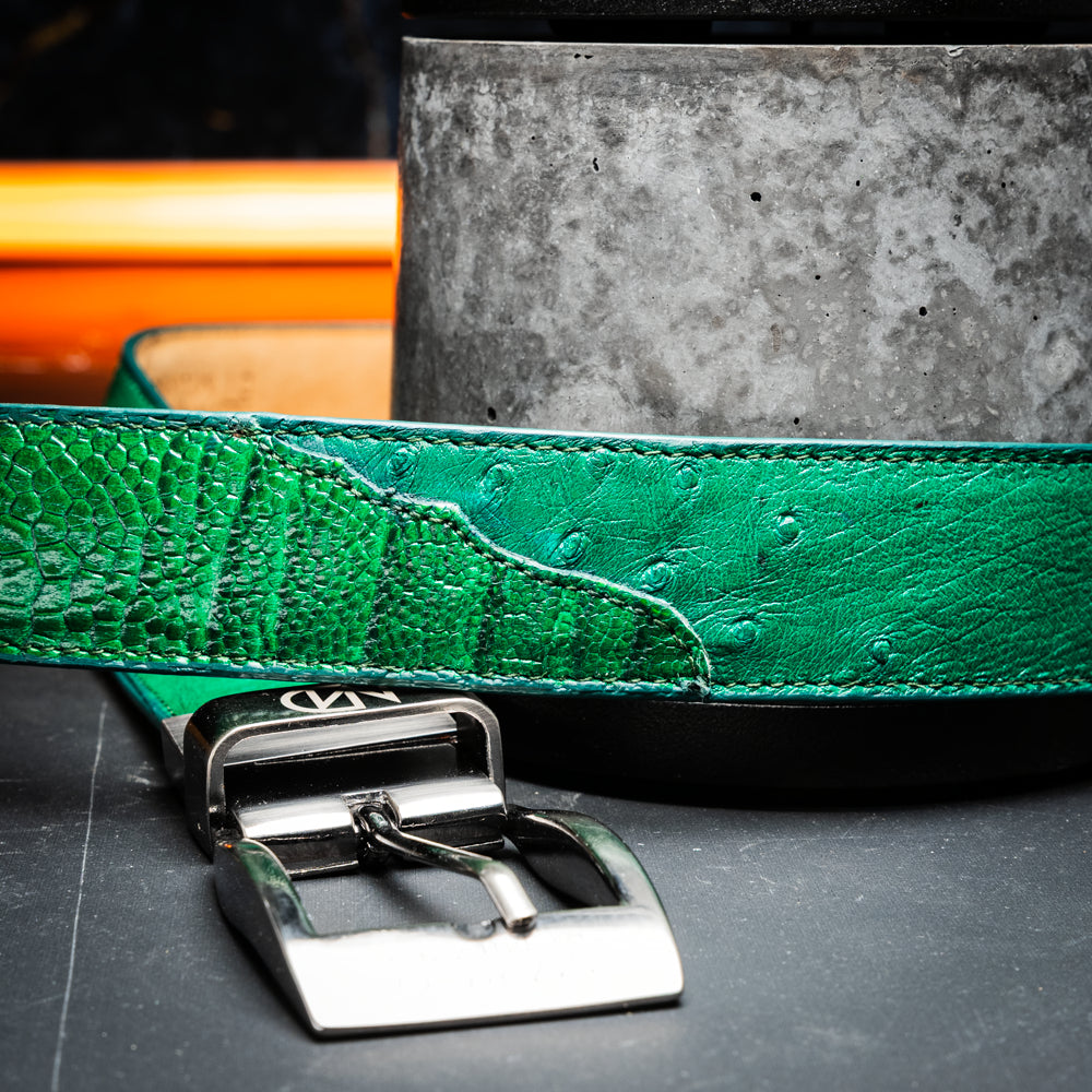 Introducing the Alessio Belt Lemon Green by Marco Di Milano—a coiled green leather belt with a silver buckle, featuring an embossed texture and the brand name “Marco Di Milano” engraved on the buckle. This handcrafted luxury accessory is designed to elevate any wardrobe with its refined elegance.