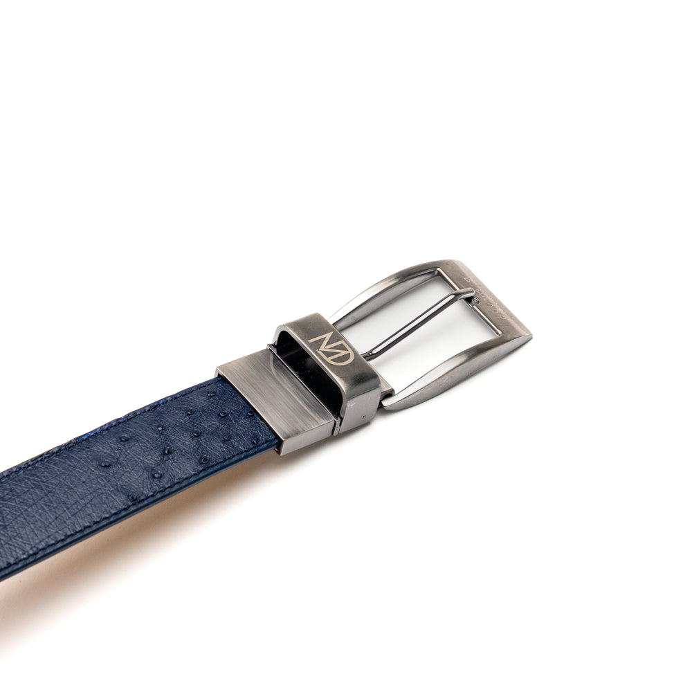 The Alessio Belt Navy by Marco Di Milano is a coiled blue handcrafted luxury belt with a silver buckle, featuring both smooth and textured crocodile-patterned sections.