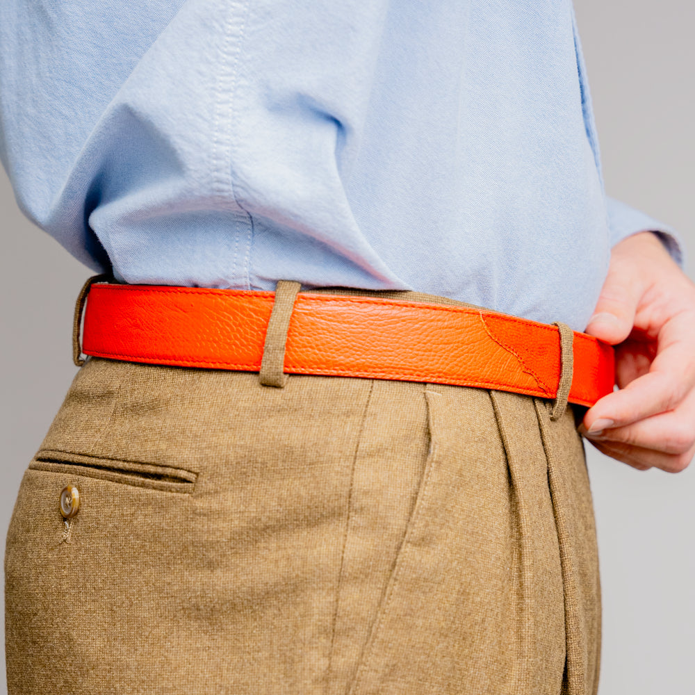 Close-up of the Alessio Belt Orange by Marco Di Milano, a handcrafted luxury accessory made from genuine orange ostrich leather, highlighting its distinctive texture and five adjustment holes against a white background.
