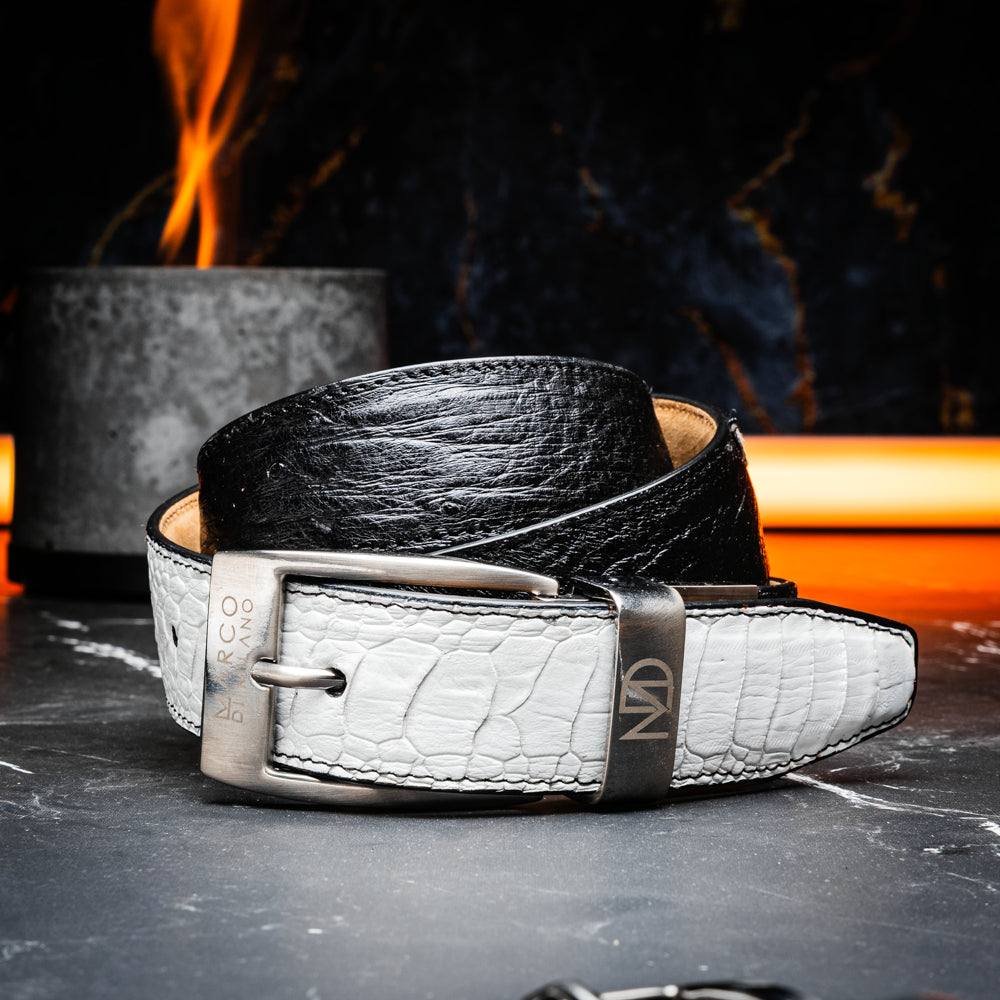 The Alessio Belt White / Black by Marco Di Milano showcases both a black and a white genuine ostrich belt, coiled together with visible textures and silver buckles engraved with the brand’s logo.