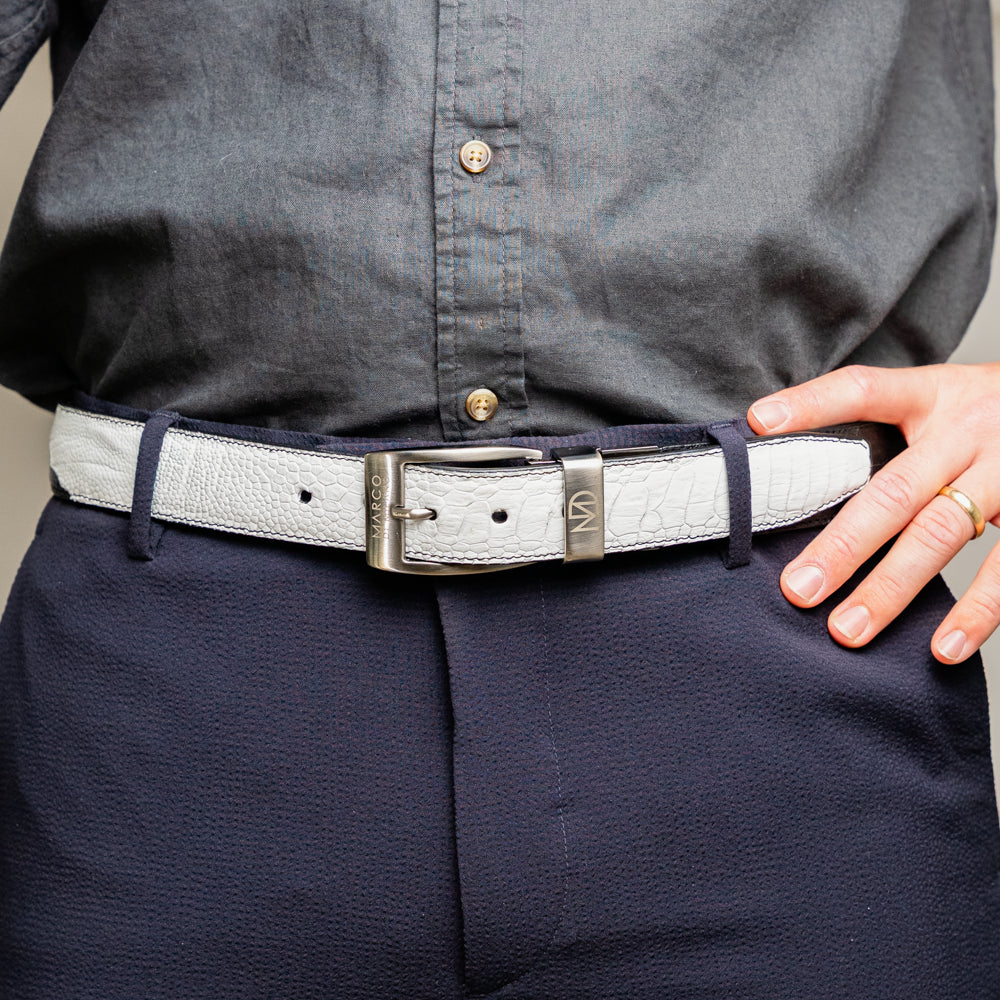 The Alessio Belt White / Black by Marco Di Milano showcases both a black and a white genuine ostrich belt, coiled together with visible textures and silver buckles engraved with the brand’s logo.