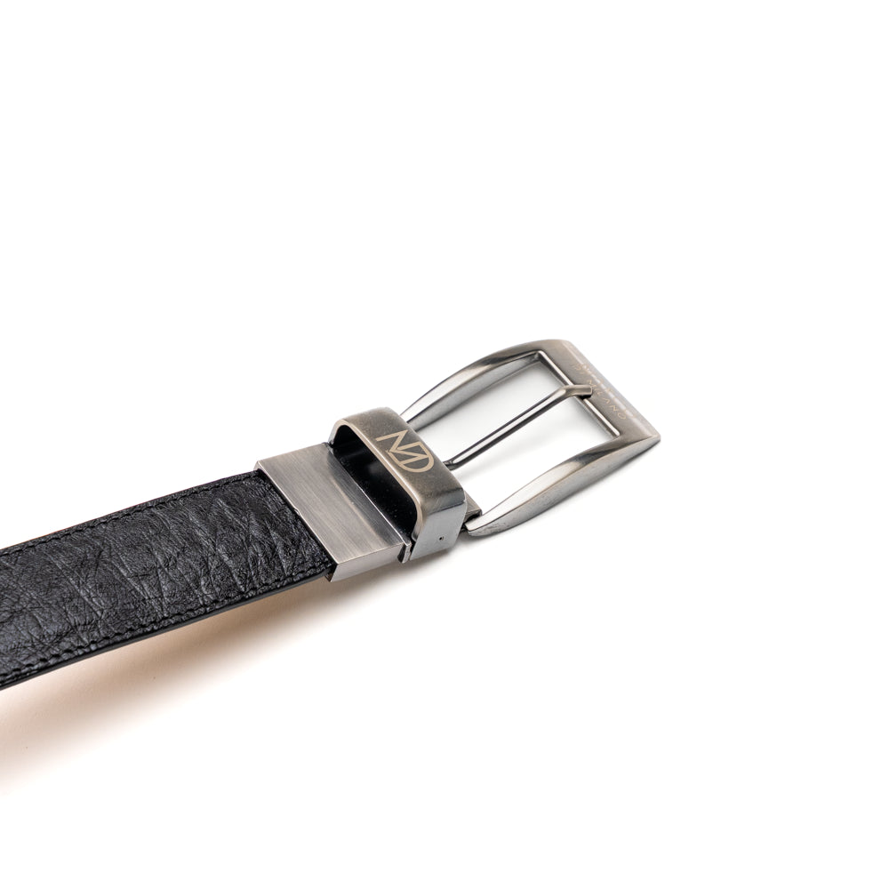 The Alessio Belt White / Black by Marco Di Milano showcases both a black and a white genuine ostrich belt, coiled together with visible textures and silver buckles engraved with the brand’s logo.