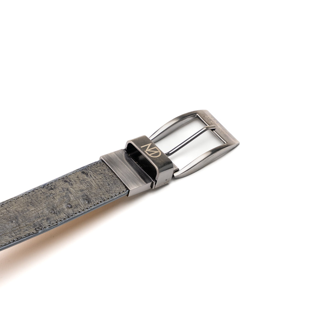Introducing the Alessio Belt White / Gray by Marco Di Milano—a handcrafted luxury accessory featuring a textured gray exotic leather strap and a distinctive white, ridged front. The metallic buckle is engraved with the Marco Di Milano logo, accentuating the exquisite craftsmanship of this elegant belt.