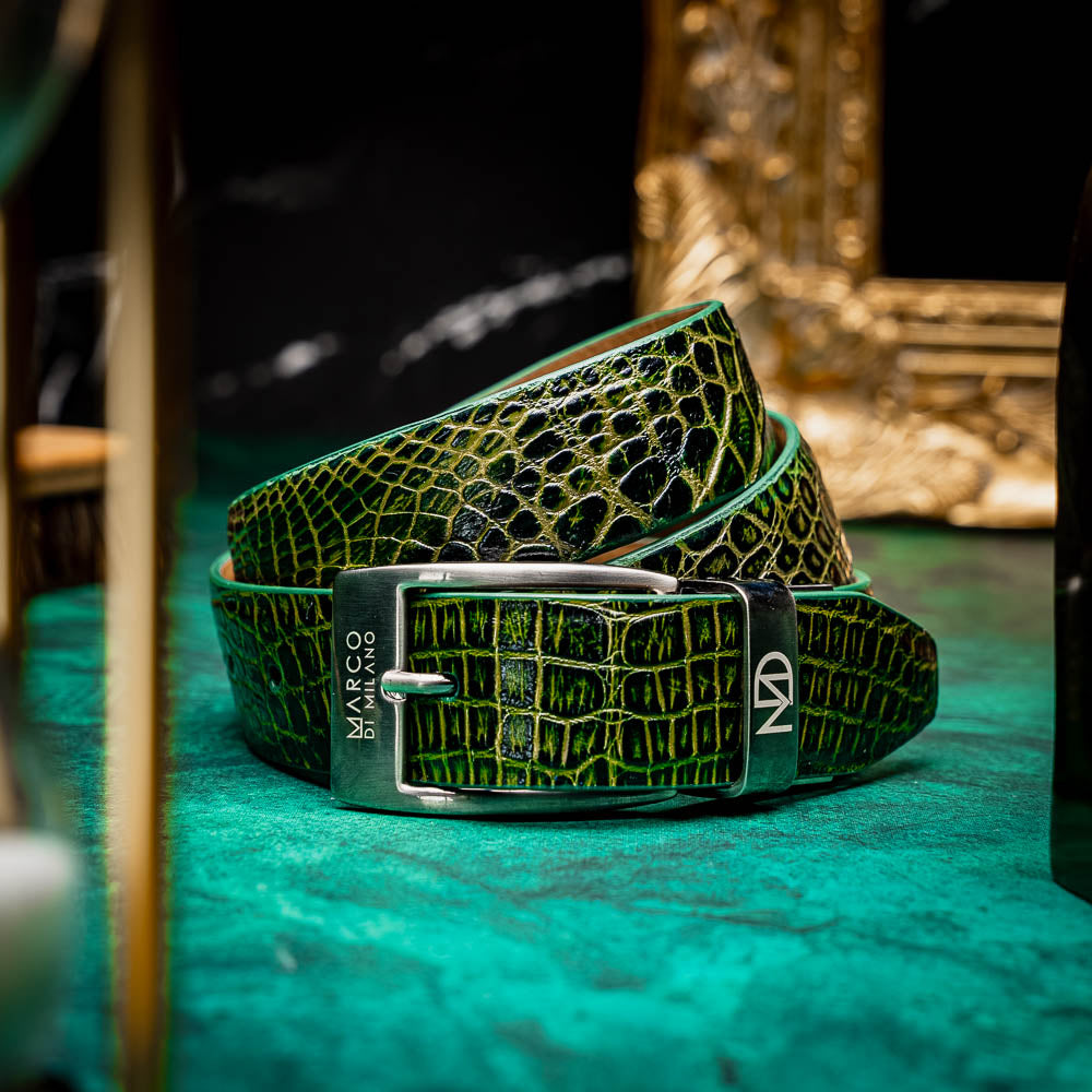 The Emilio Belt Antique Green by Marco Di Milano features textured green leather with a crocodile pattern and a silver, logo-engraved buckle—ideal for pairing with genuine alligator belts and luxury footwear.