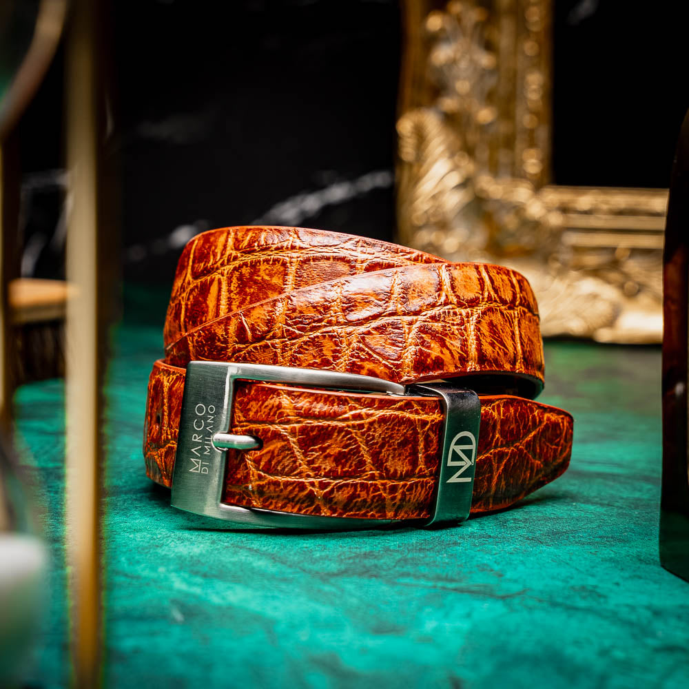 The Emilio Belt Antique Honey by Marco Di Milano features a textured crocodile-pattern finish and a branded metal buckle—an elegant accessory that pairs perfectly with luxury footwear or genuine alligator belts.