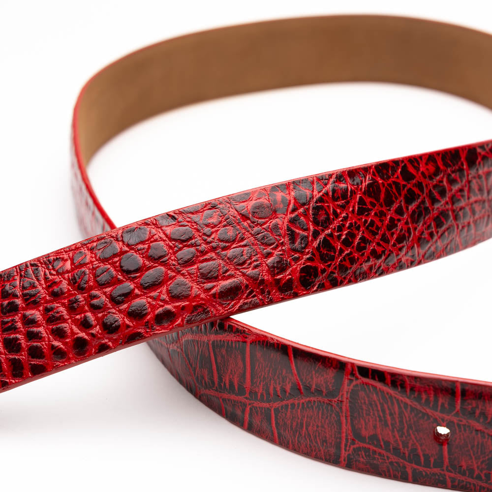 The Emilio Belt Antique Red by Marco Di Milano is a rolled-up red crocodile-patterned leather belt with hand-painted finishes and a silver buckle, displayed on a white background.