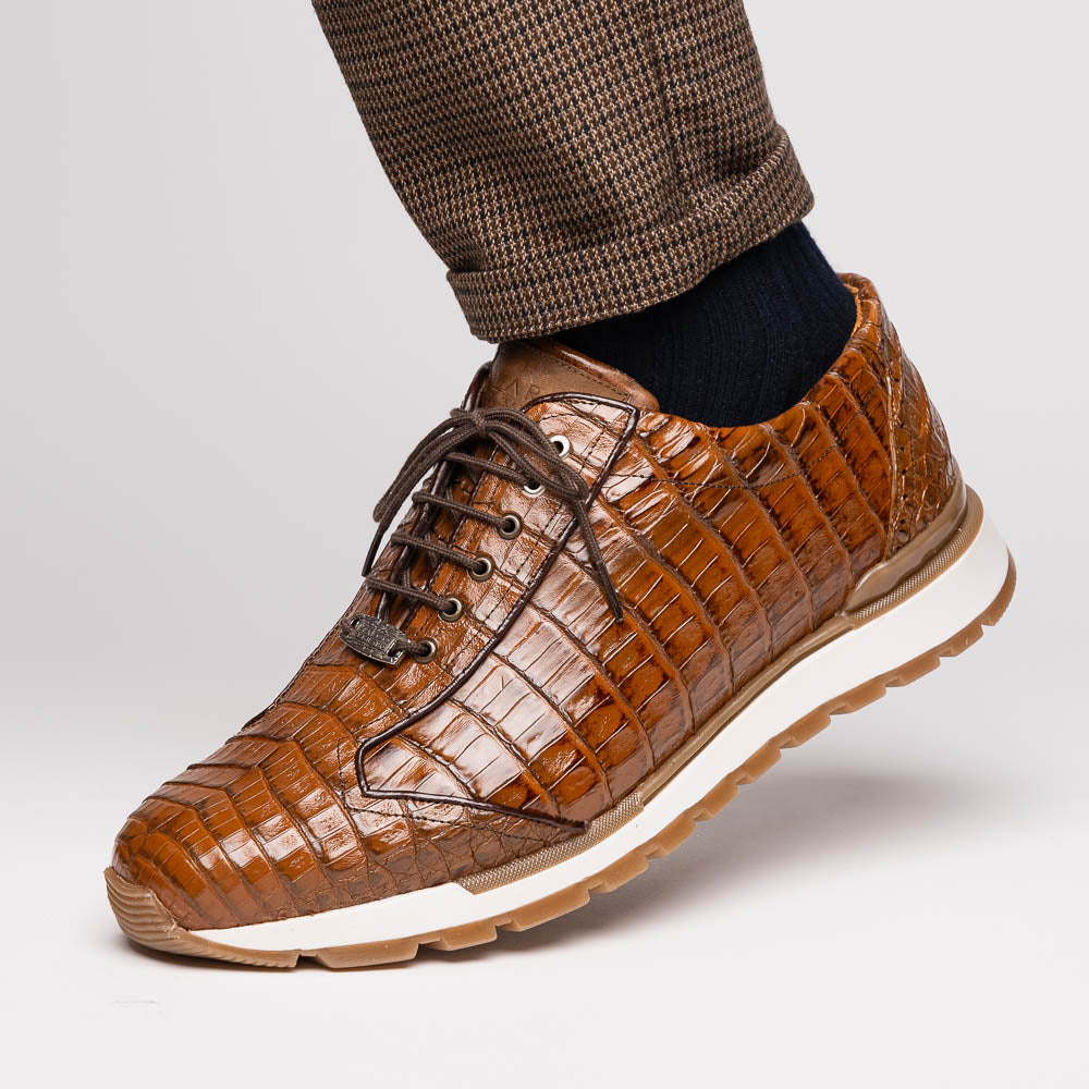 The Marco Di Milano Alonzo Bay Apache sneakers feature brown genuine caiman crocodile leather, white midsoles, brown rubber outsoles, a lace-up design, and a textured pattern—luxury footwear ideal for any occasion.