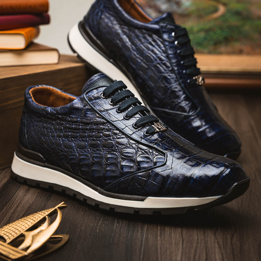The Alonzo Navy by Marco Di Milano is a luxury men's sneaker in genuine caiman crocodile leather, featuring black laces, a hand-painted finish, white midsole, and black textured outsole.