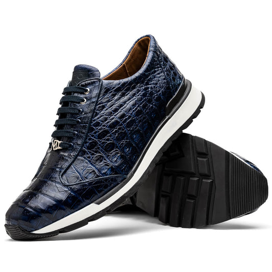The Marco Di Milano Alonzo Navy sneakers are luxury dark blue genuine caiman crocodile shoes with hand-painted finish, black laces, and white midsoles—one stands upright while the other is on its side showing the sole.