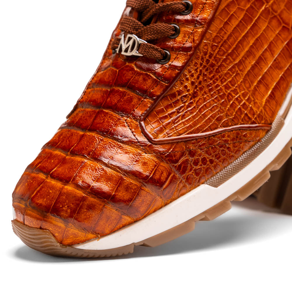 The Alonzo Cognac sneaker by Marco Di Milano features a hand-painted brown caiman crocodile-patterned leather upper and a white-brown rubber sole—luxury footwear for discerning tastes, shown in a sleek side view.