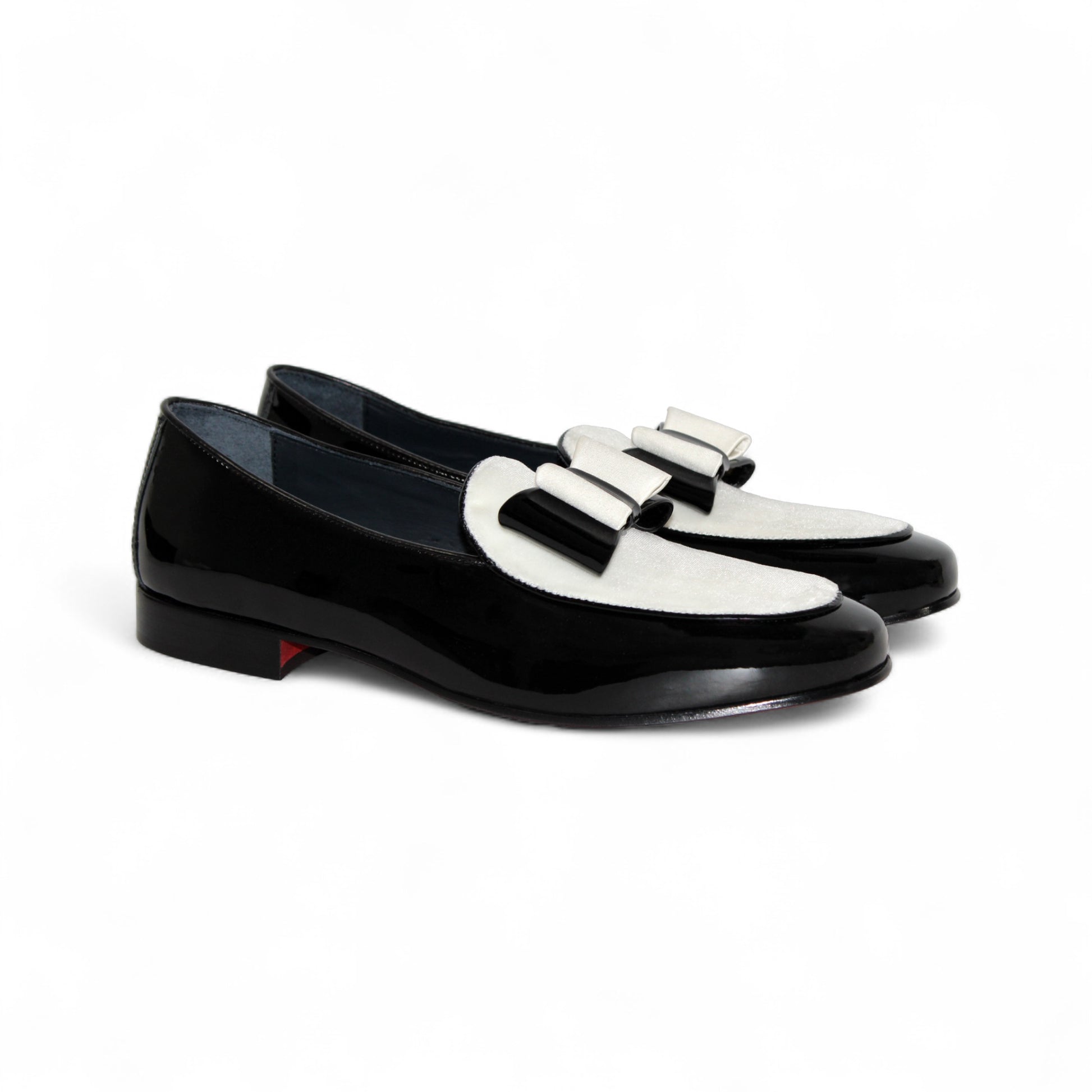 The Duca Di Matiste Amalfi loafer in black and white features a patent leather design, low heel, decorative bow, and Italian craftsmanship. Available in store size 9.5 only (final sale), shown on a plain white background.