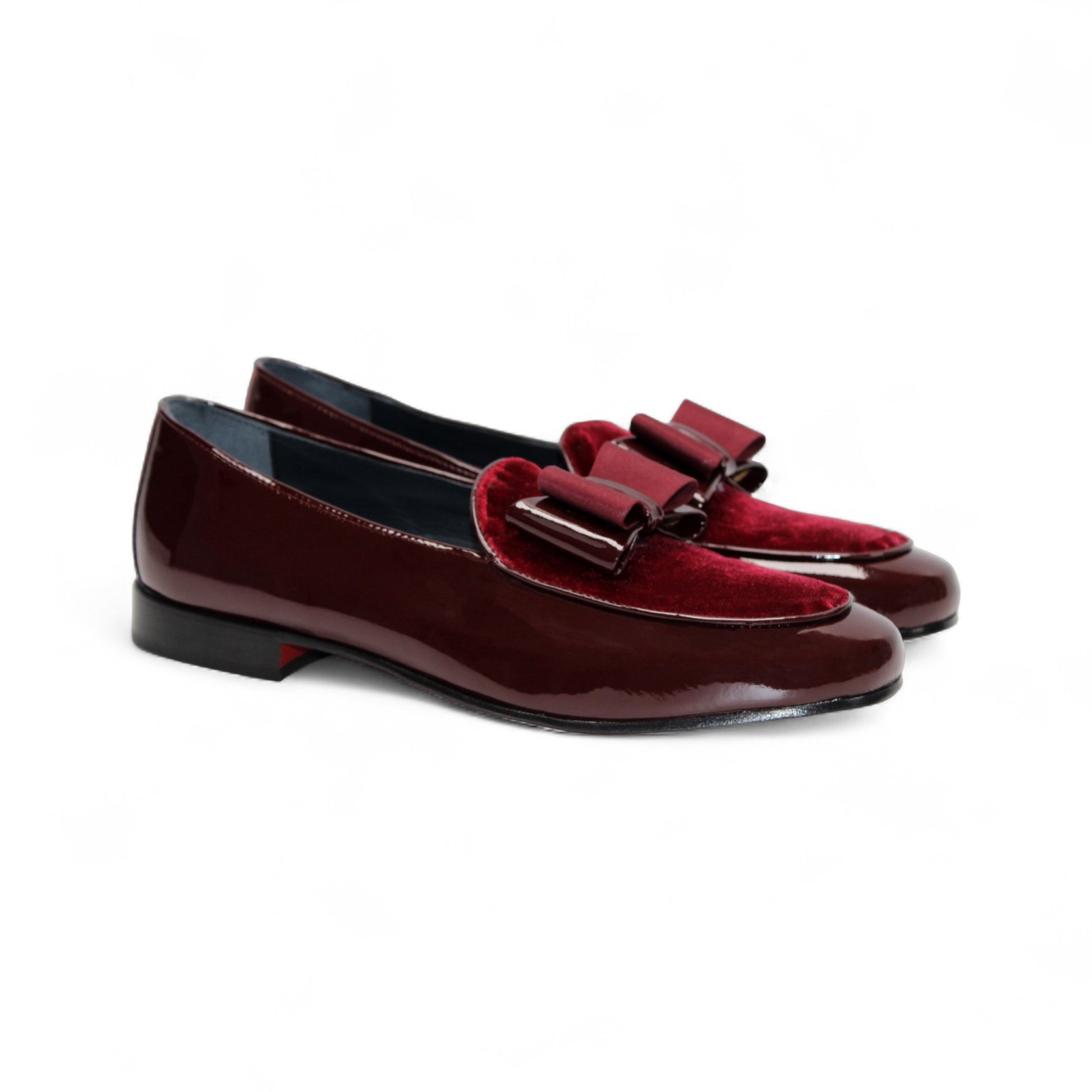 The Duca Amalfi Burgundy by Duca Di Matiste, a burgundy patent leather loafer with a low heel and matching bow, is shown side view on white, capturing refined Italian luxury and expert craftsmanship.