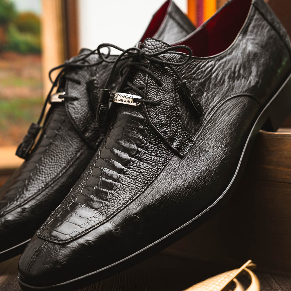 A pair of Andretti Black shoes by Marco Di Milano—one upright to reveal the textured upper, the other on its side showing the brown branded sole—showcasing luxury men's footwear.