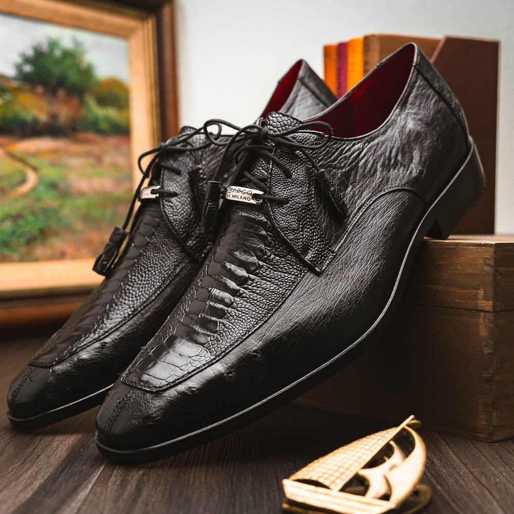 A pair of Andretti Black shoes by Marco Di Milano—one upright to reveal the textured upper, the other on its side showing the brown branded sole—showcasing luxury men's footwear.
