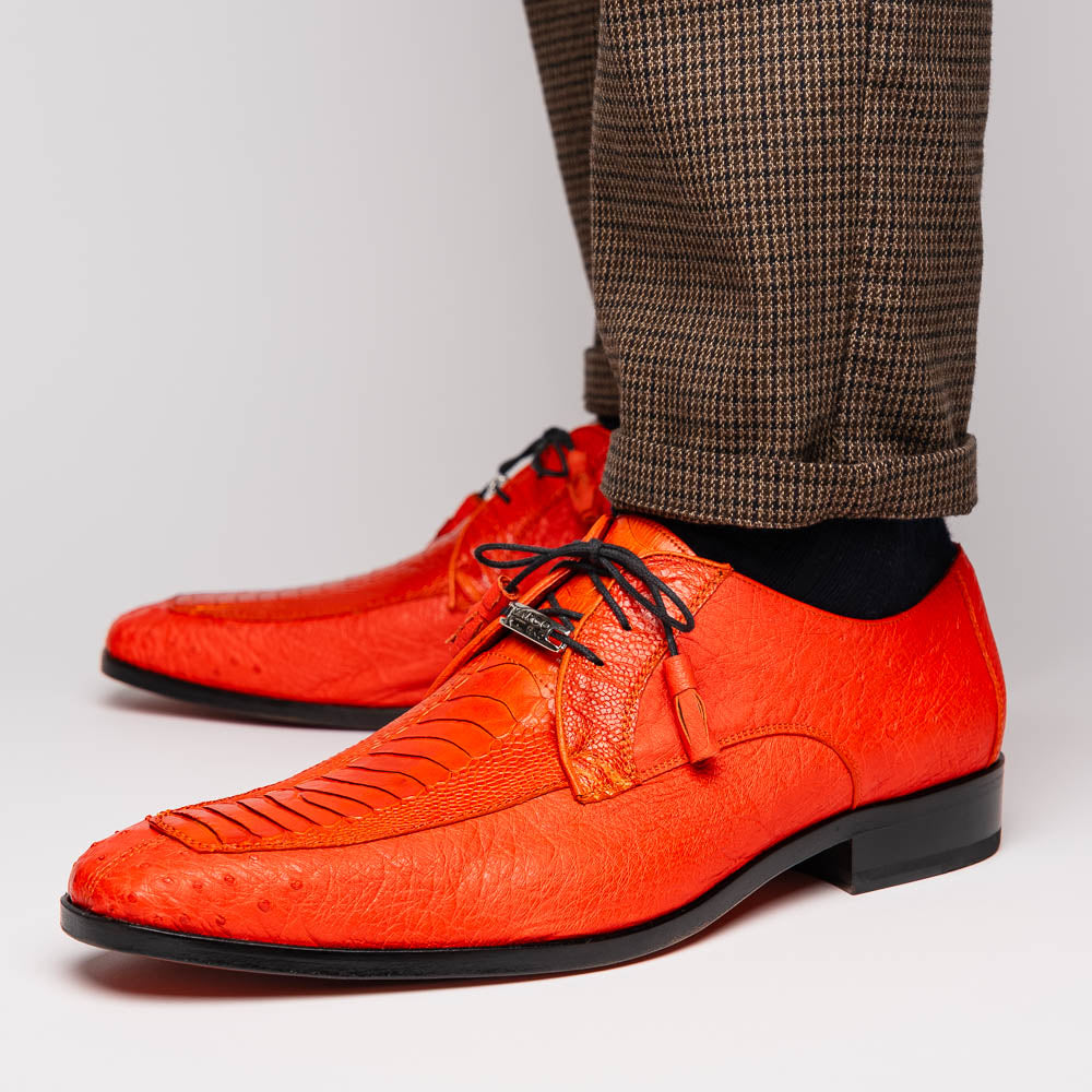 The Andretti Orange by Marco Di Milano are vibrant orange leather dress shoes with black laces and textured detailing, one upright and one showing the branded sole—ideal luxury footwear for men.