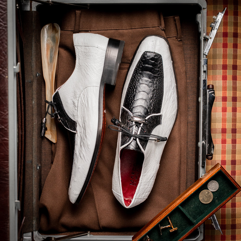 A pair of men’s luxury Andretti Black / White dress derby shoes from Marco Di Milano, these genuine ostrich leather shoes showcase elegant white uppers with black lace-up detailing; one shoe is shown upright while the other displays the rich brown sole.