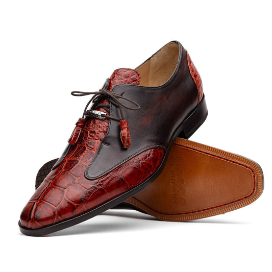 The Anzio Rustic Cognac by Marco Di Milano is a men's dress shoe featuring red and brown crocodile-patterned leather, lace-up closure, tassel accents, and leather soles—an elevated choice in luxury footwear.