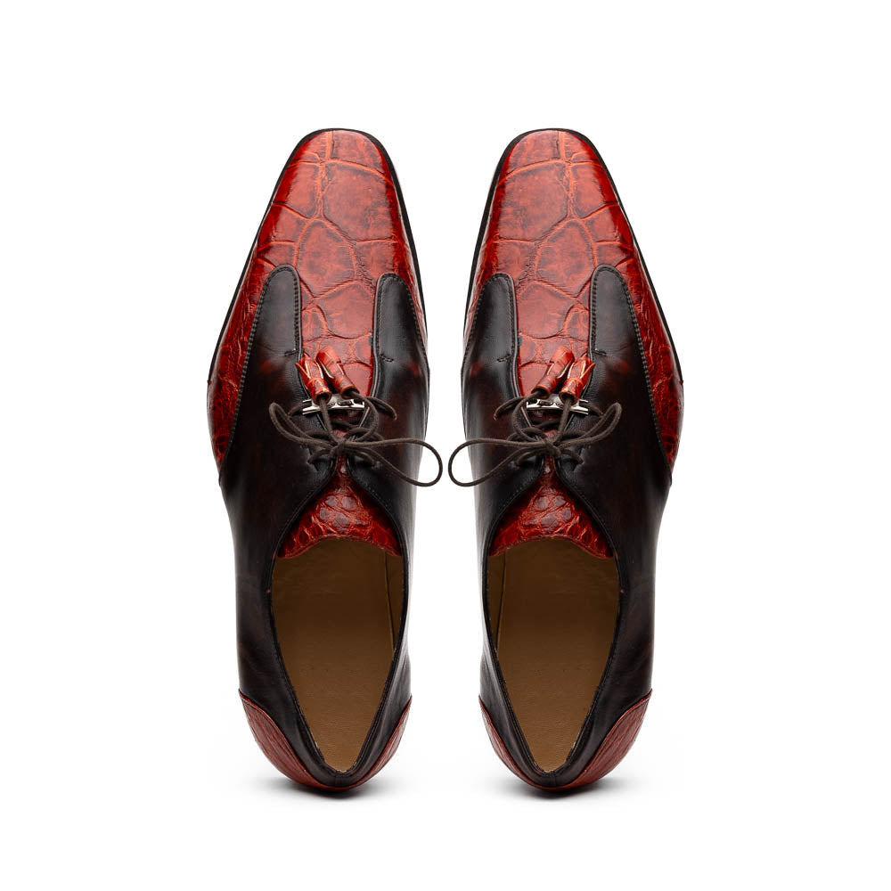 The Anzio Rustic Cognac by Marco Di Milano is a men's dress shoe featuring red and brown crocodile-patterned leather, lace-up closure, tassel accents, and leather soles—an elevated choice in luxury footwear.