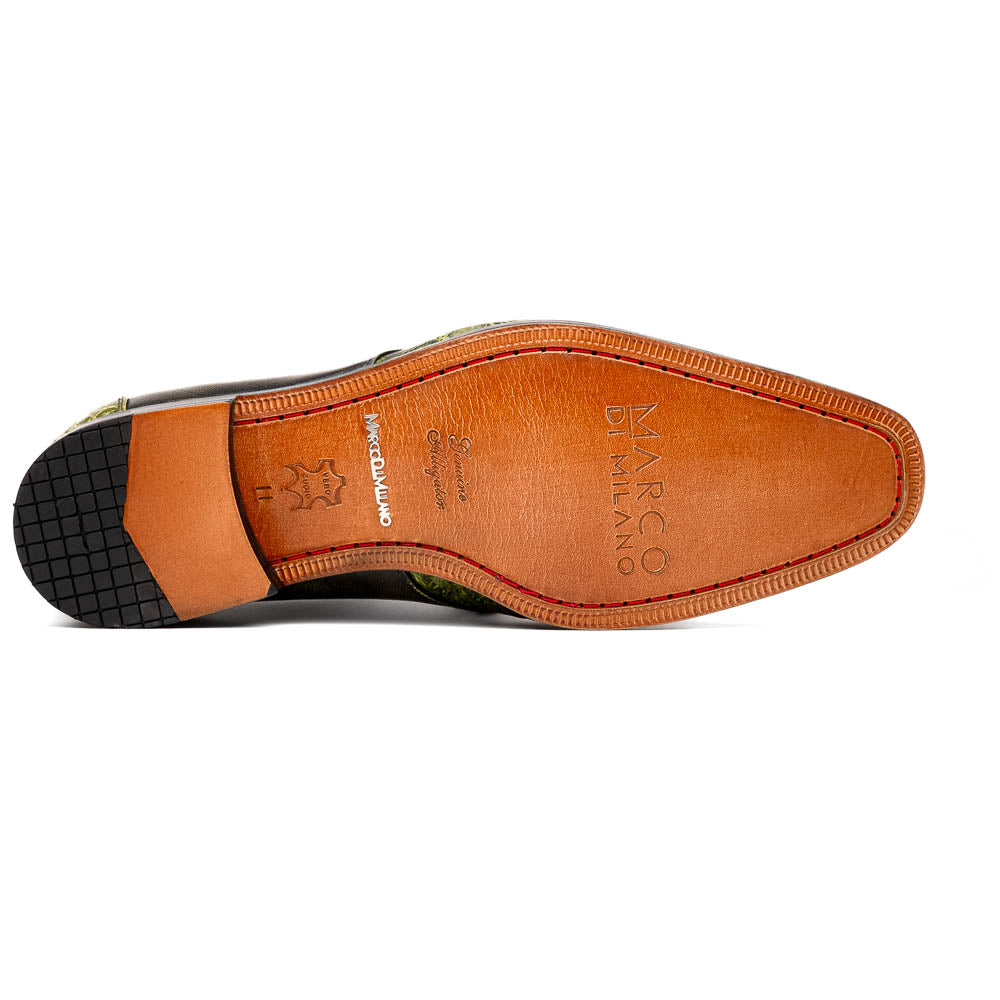 A pair of Anzio Rustic Green men's dress shoes by Marco Di Milano, featuring a green textured finish, black laces, and brown leather soles—one upright and one lying on its side.