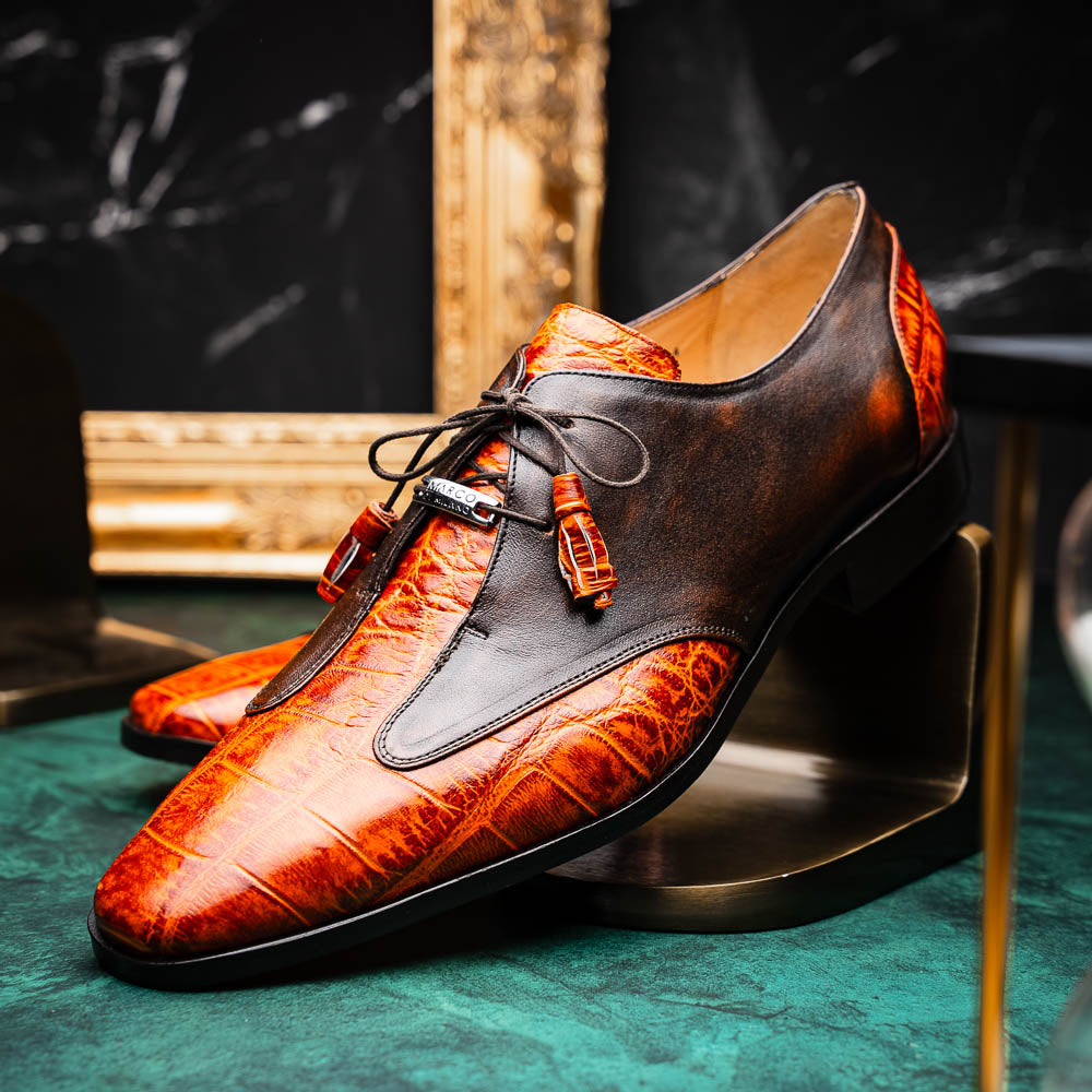 Step out in style with the Marco Di Milano Anzio Rustic Brandy men's leather dress shoes, showcasing a brown and orange crocodile pattern, lace-up closure, and "MARCO" branding—perfect for those who appreciate luxury footwear.