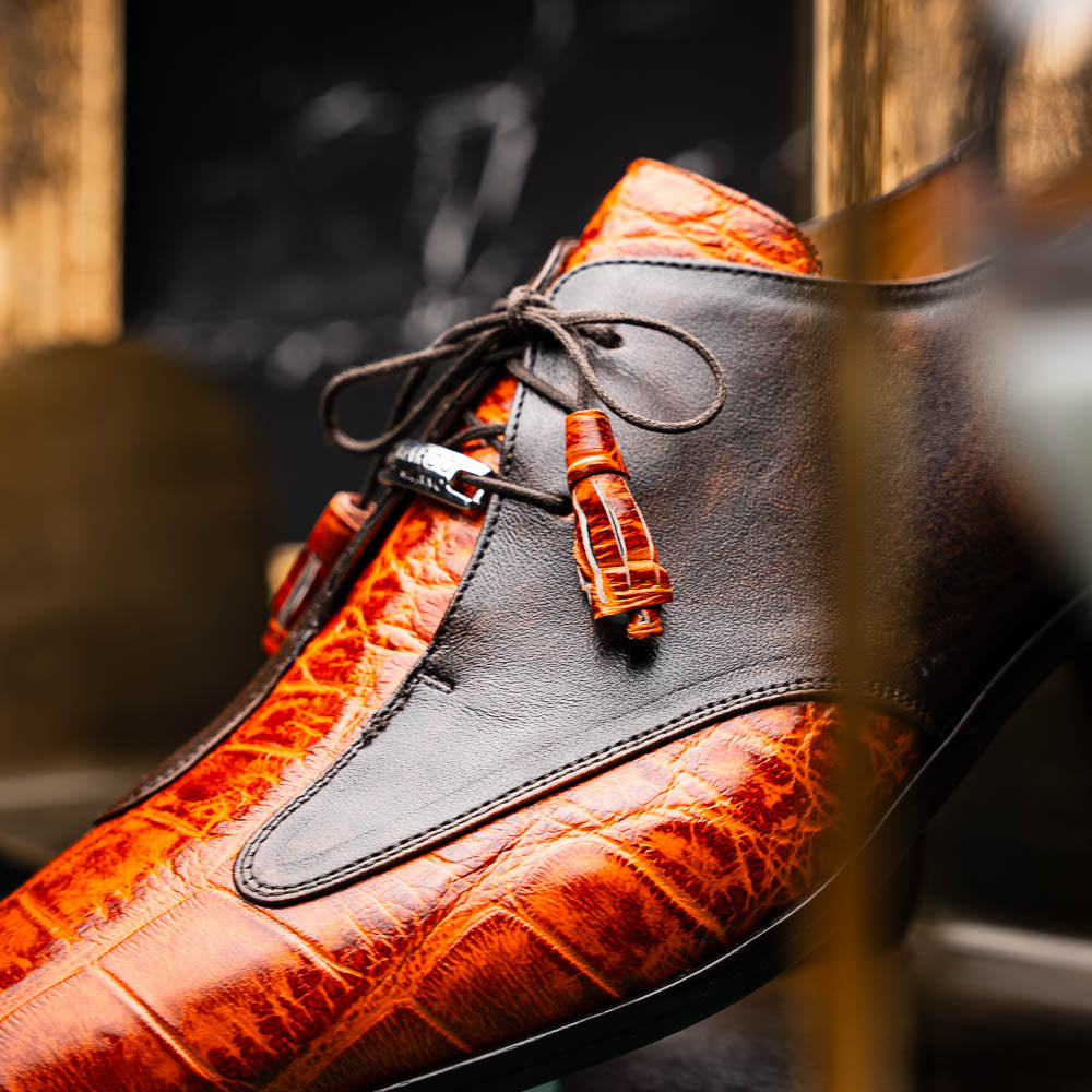 Step out in style with the Marco Di Milano Anzio Rustic Brandy men's leather dress shoes, showcasing a brown and orange crocodile pattern, lace-up closure, and "MARCO" branding—perfect for those who appreciate luxury footwear.