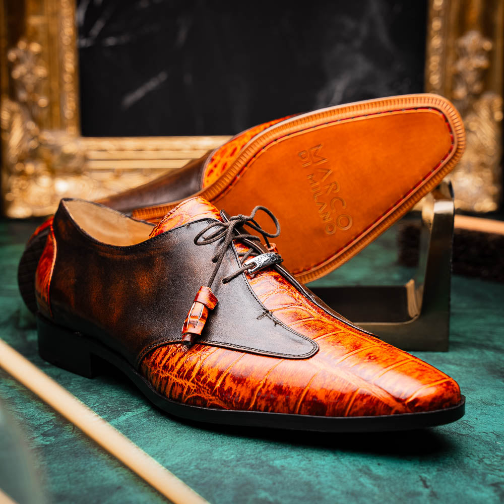 Step out in style with the Marco Di Milano Anzio Rustic Brandy men's leather dress shoes, showcasing a brown and orange crocodile pattern, lace-up closure, and "MARCO" branding—perfect for those who appreciate luxury footwear.