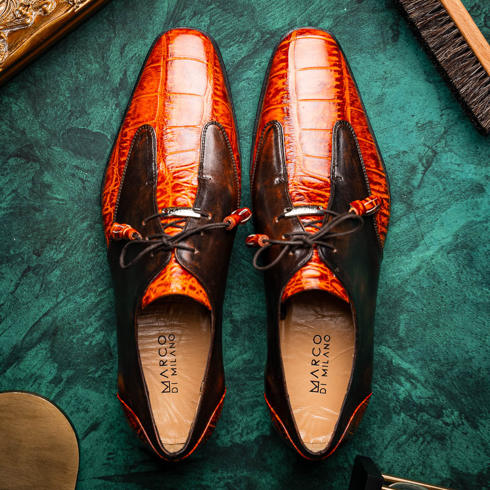 Step out in style with the Marco Di Milano Anzio Rustic Brandy men's leather dress shoes, showcasing a brown and orange crocodile pattern, lace-up closure, and "MARCO" branding—perfect for those who appreciate luxury footwear.