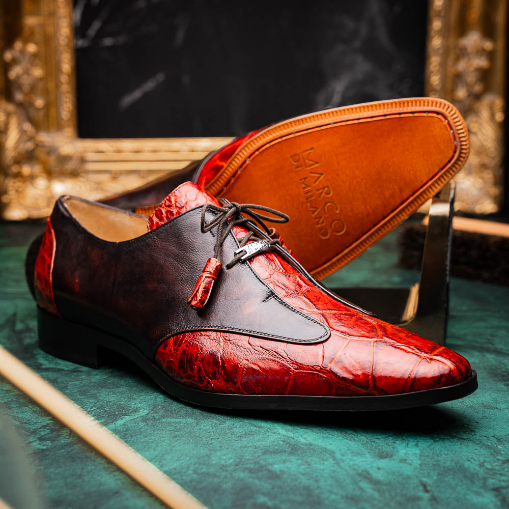 The Anzio Rustic Cognac by Marco Di Milano is a men's dress shoe featuring red and brown crocodile-patterned leather, lace-up closure, tassel accents, and leather soles—an elevated choice in luxury footwear.