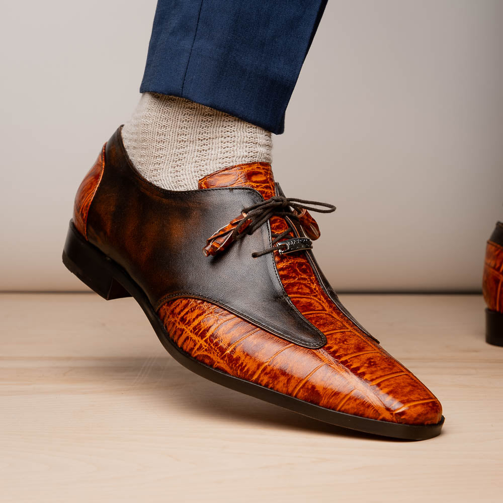 Step out in style with the Marco Di Milano Anzio Rustic Brandy men's leather dress shoes, showcasing a brown and orange crocodile pattern, lace-up closure, and "MARCO" branding—perfect for those who appreciate luxury footwear.