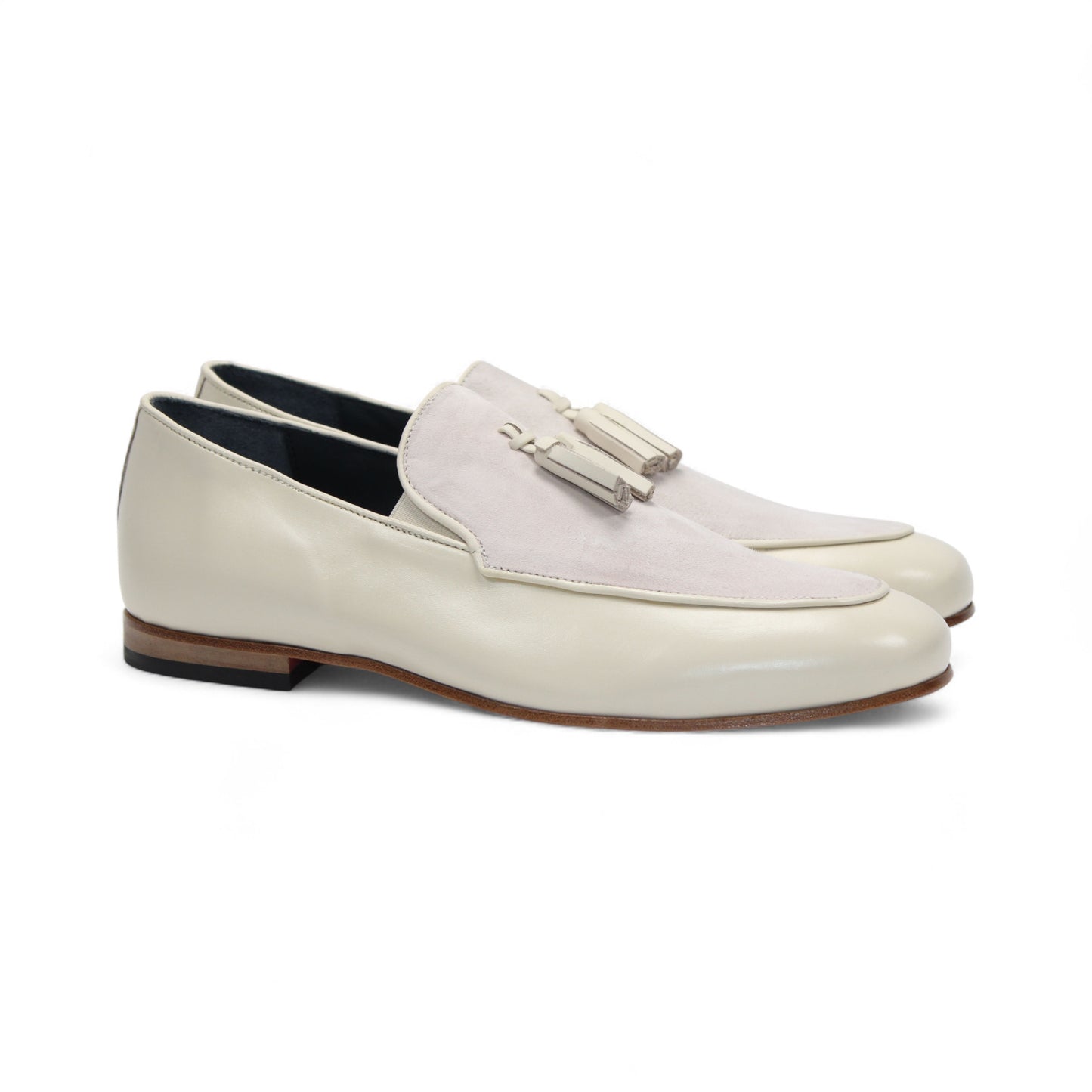 The Duca Anzio Cream by Duca Di Matiste is a men's loafer featuring cream and light beige tones, tassel detail, low wooden heel, and a smooth leather finish for refined minimalist style in a sleek side profile.