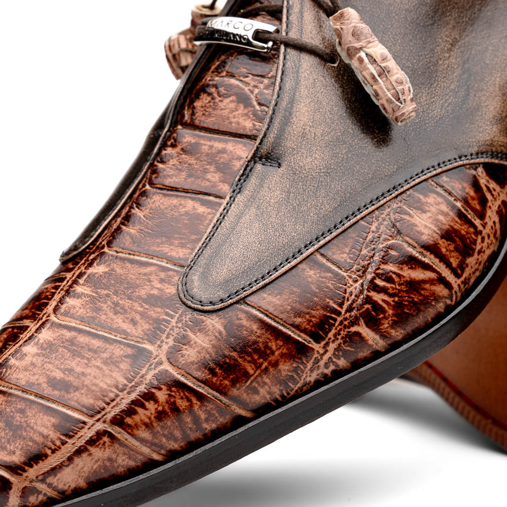 A pair of Anzio Rustic Orix brown leather dress shoes by Marco Di Milano, featuring a textured crocodile pattern—one upright, the other showing a smooth tan sole—represent true luxury men's footwear.