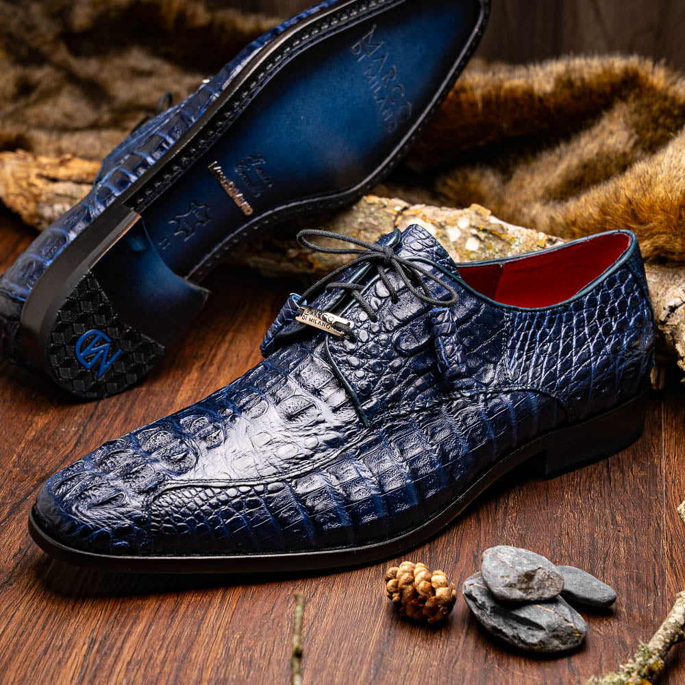 A pair of Marco Di Milano Apricena Midnight Blue caiman crocodile derby shoes, one upright and the other on its side showing the sole, with black laces for a luxury dress look.