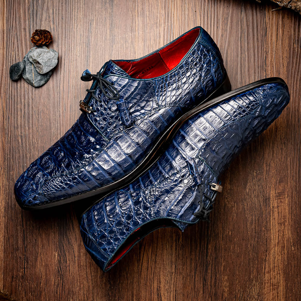 A pair of Marco Di Milano Apricena Midnight Blue caiman crocodile derby shoes, one upright and the other on its side showing the sole, with black laces for a luxury dress look.