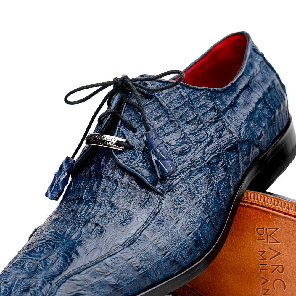 The Apricena Navy by Marco Di Milano are blue textured luxury men's dress shoes with black laces, red interior lining, and branded tan leather soles—crafted to evoke the refined look of genuine caiman crocodile shoes.