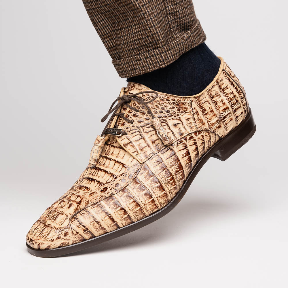 A pair of Marco Di Milano Apricena Rustic Orix luxury dress shoes in beige crocodile pattern, one upright and one on its side revealing the brown sole with embossed branding. Made from genuine caiman crocodile leather for an elegant finish.