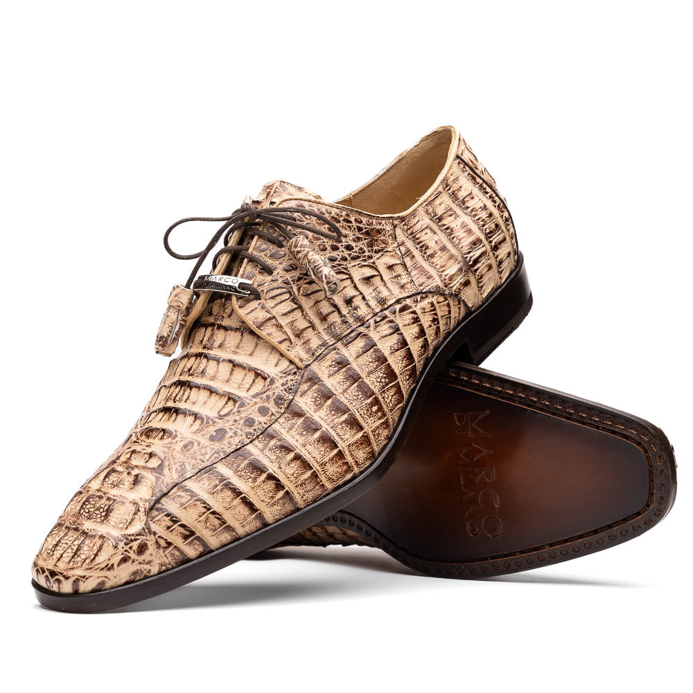 A pair of Marco Di Milano Apricena Rustic Orix luxury dress shoes in beige crocodile pattern, one upright and one on its side revealing the brown sole with embossed branding. Made from genuine caiman crocodile leather for an elegant finish.