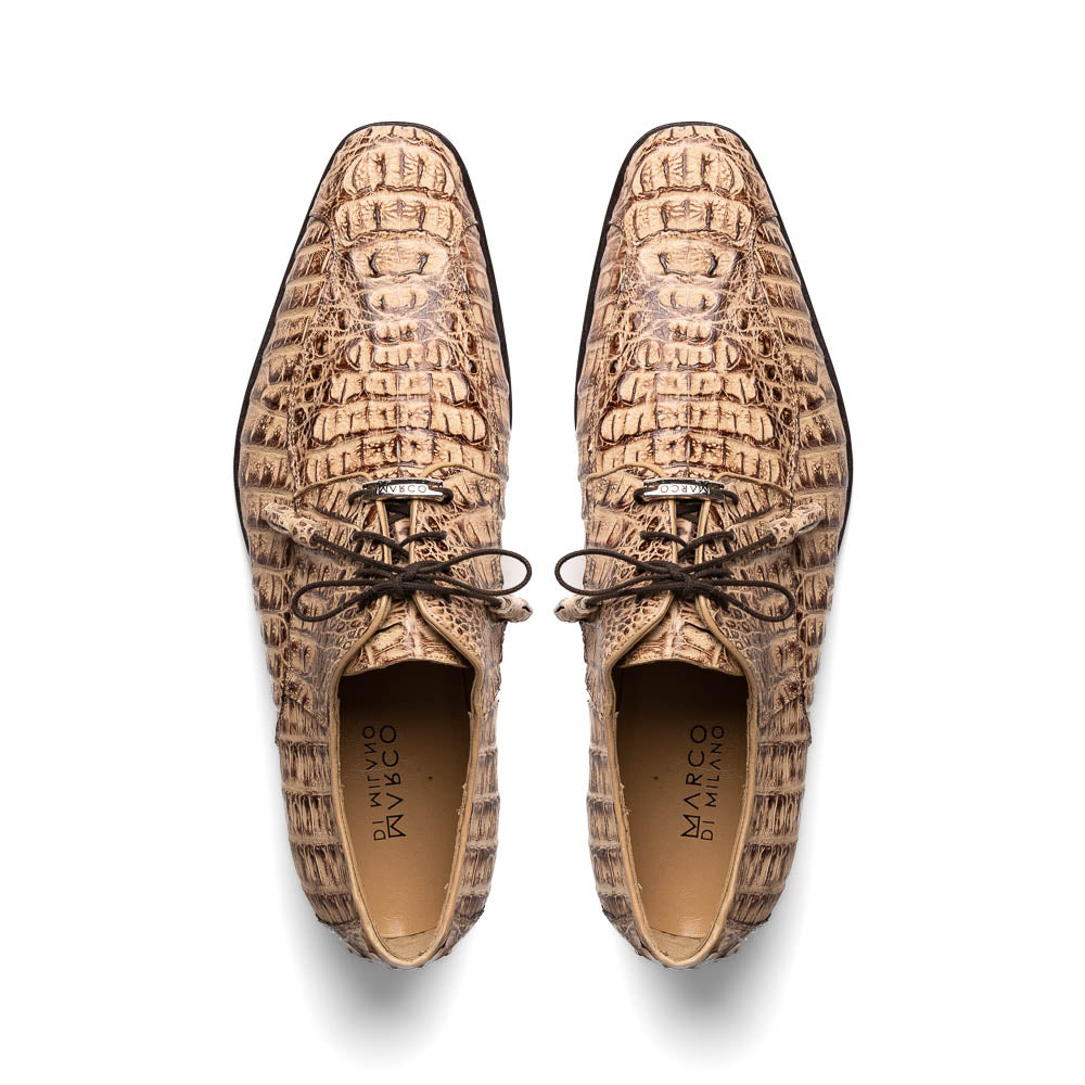 A pair of Marco Di Milano Apricena Rustic Orix luxury dress shoes in beige crocodile pattern, one upright and one on its side revealing the brown sole with embossed branding. Made from genuine caiman crocodile leather for an elegant finish.