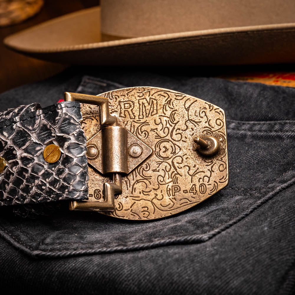 The Arkansas Belt Antique Newspaper by Marco Di Milano features genuine python skin in black and silver, a large gold “MD” buckle, and “MARCO MILANO” text on the tip, fusing exotic style with luxury craftsmanship.