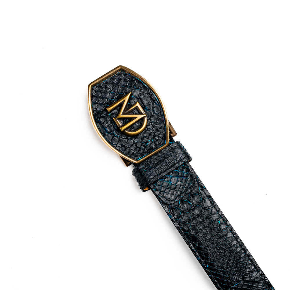 The Arkansas Belt Black / Blue by Marco Di Milano features a handcrafted black snakeskin pattern and a gold and black "MD" buckle, displayed against a white background.