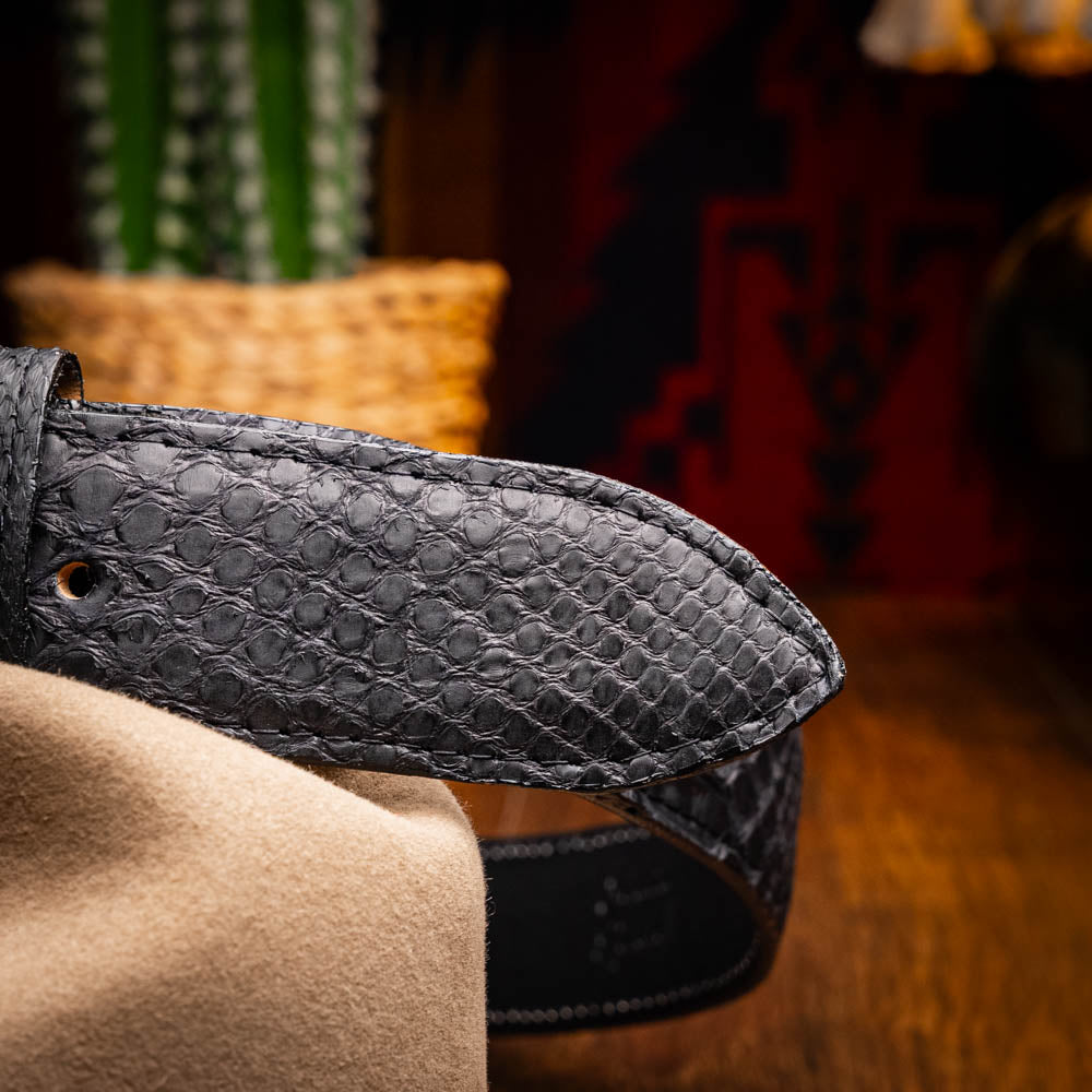The Arkansas Belt Black by Marco Di Milano features textured black leather and a gold MD monogram buckle, shown coiled on a white background.