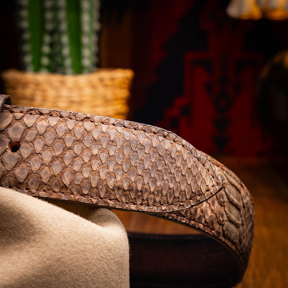 The Arkansas Belt Brown by Marco Di Milano is a handcrafted western accessory in genuine python skin, featuring a gold-tone buckle with overlapping "M" and "D" letters.