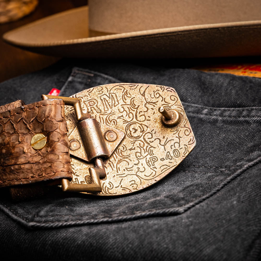 The Arkansas Belt Brown by Marco Di Milano is a handcrafted western accessory in genuine python skin, featuring a gold-tone buckle with overlapping "M" and "D" letters.