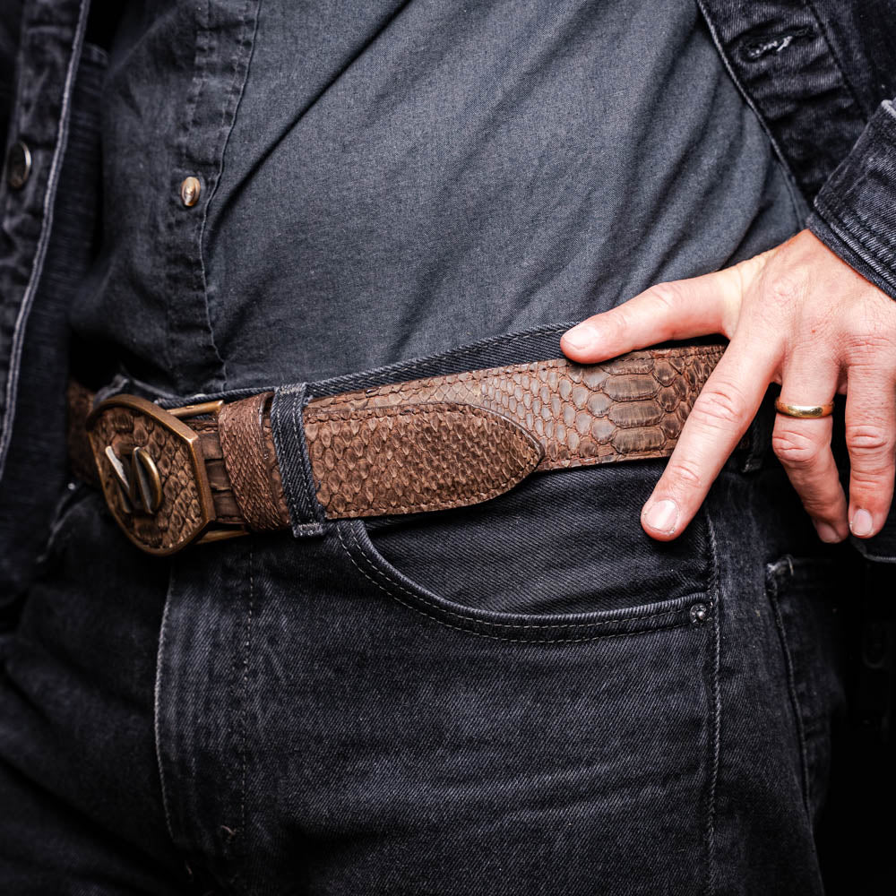 The Arkansas Belt Brown by Marco Di Milano is a handcrafted western accessory in genuine python skin, featuring a gold-tone buckle with overlapping "M" and "D" letters.