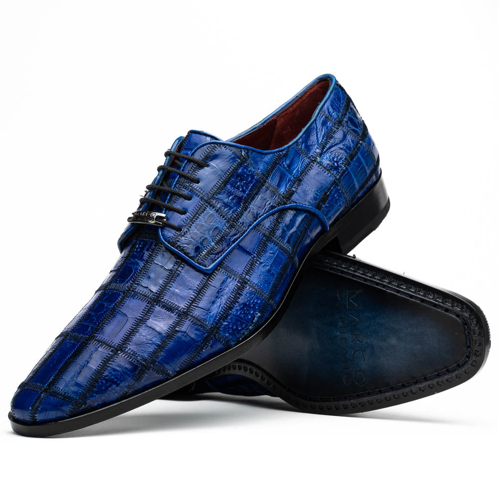 The Asti Electric Blue by Marco Di Milano features hand-painted blue crocodile-patterned leather dress shoes—one upright, one on its side showing the sole—highlighting genuine exotic craftsmanship and luxury style.