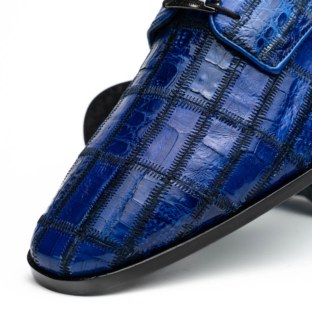 The Asti Electric Blue by Marco Di Milano features hand-painted blue crocodile-patterned leather dress shoes—one upright, one on its side showing the sole—highlighting genuine exotic craftsmanship and luxury style.