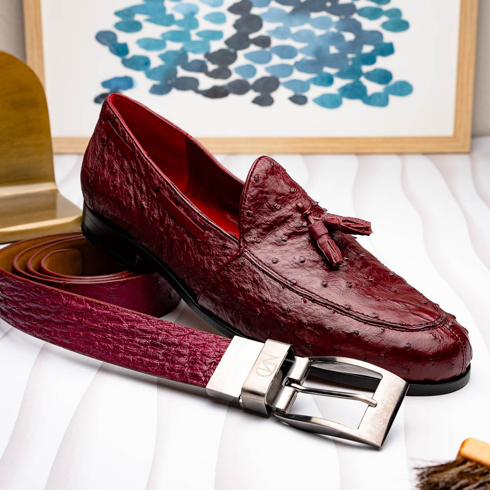 The Domenico Belt Wine by Marco Di Milano is crafted from maroon leather with an exotic ostrich texture and a silver buckle engraved with "Marco Di Milano" and "MD", featuring exquisite hand-painted finishes to complement luxury footwear.
