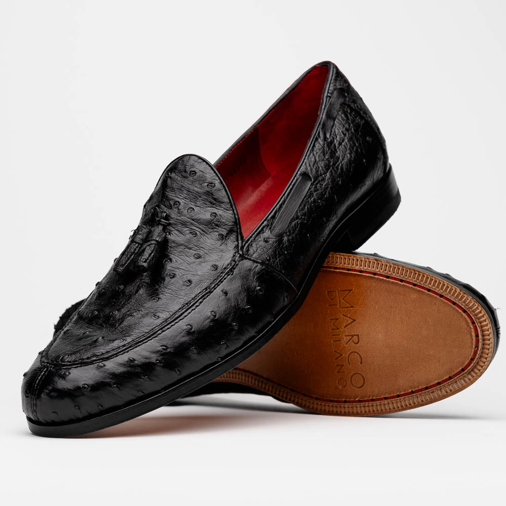 The Aubiere Black by Marco Di Milano are luxury men's tassel loafers in black genuine ostrich leather, shown with one shoe upright and the other displaying a tan sole embossed with the Marco Di Milano logo.